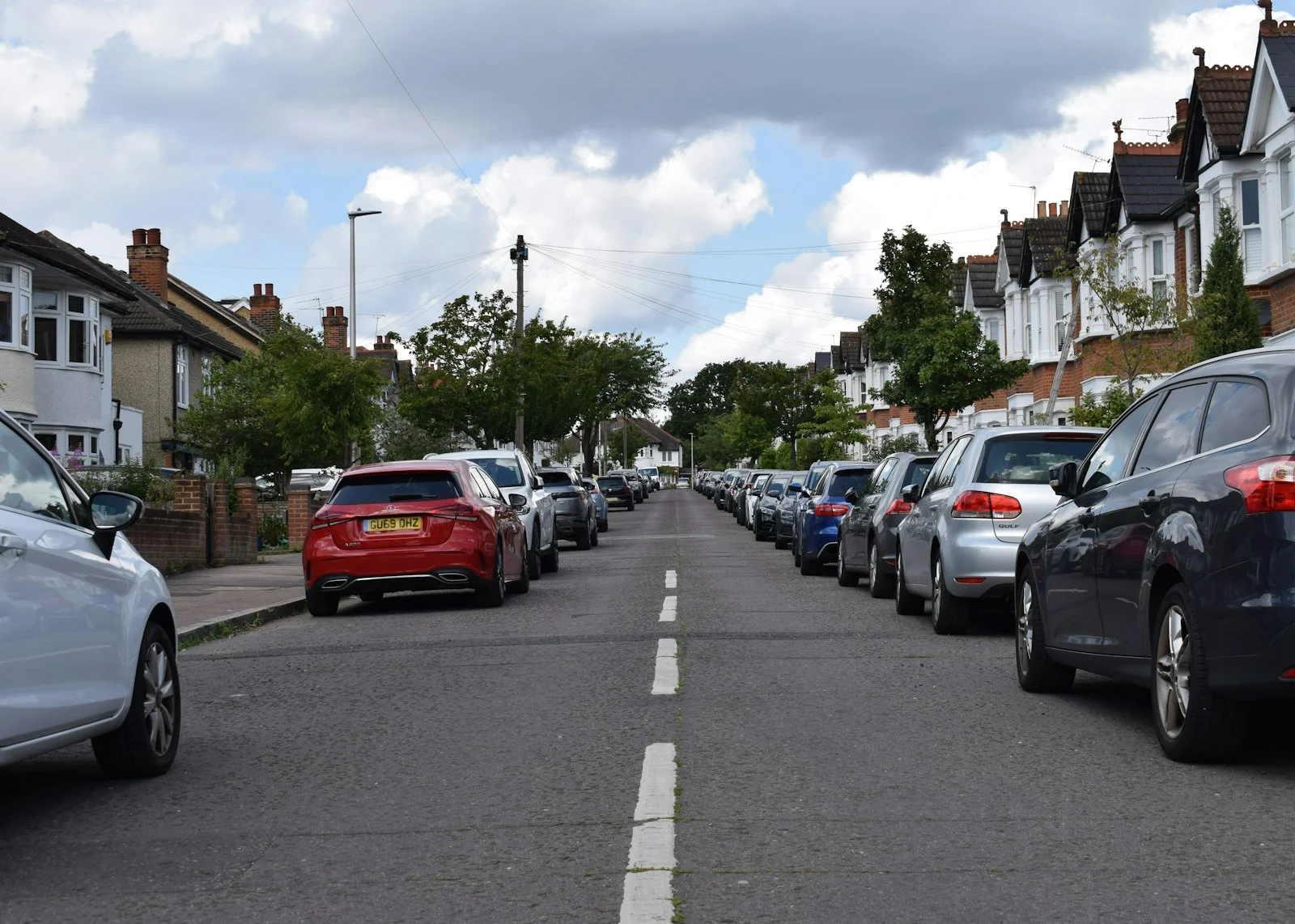 a row of parked cars on a residential street a row of parked cars on a residential street
