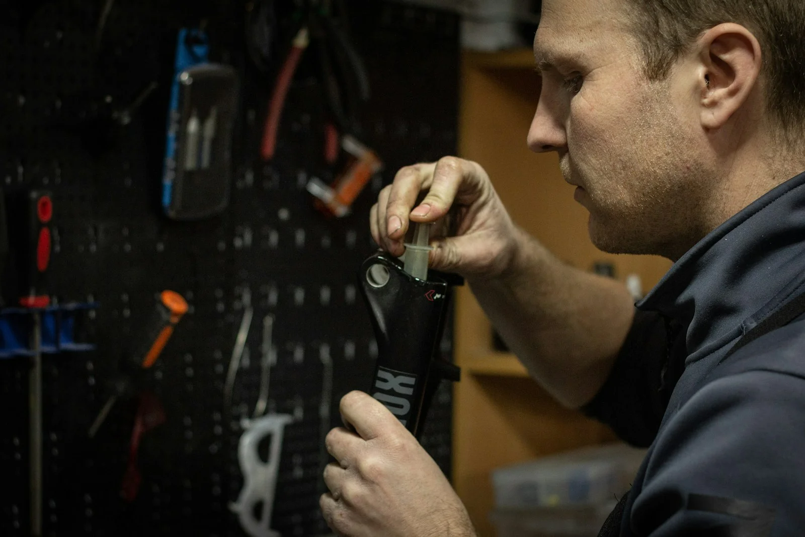 a man working on a tool in a garage a man working on a tool in a garage